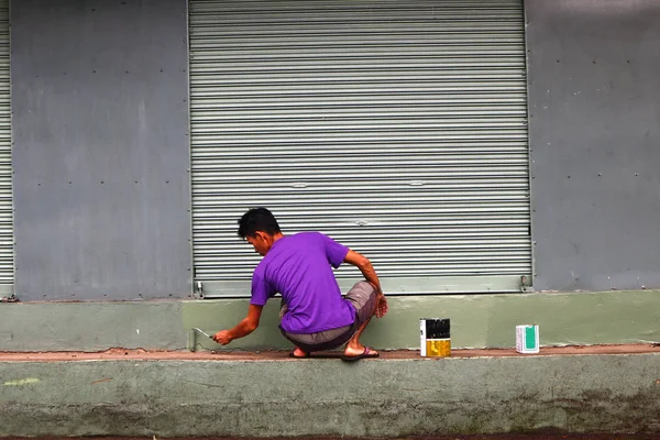Adult Filipino man painting wall of building — Stock Photo, Image