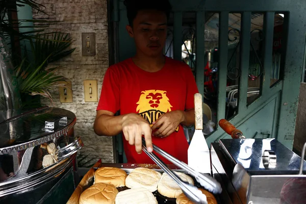 Vendedor de alimentos prepara hamburguesa y hamburguesa de queso para el cliente en su puesto de comida . — Foto de Stock