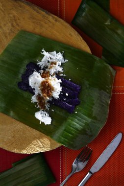 Yeni pişirilmiş Filipin lezzetinin fotoğrafı. Adı puto bumbong veya bambu tüplerinde pişirilmiş mor glutenöz pirinç.