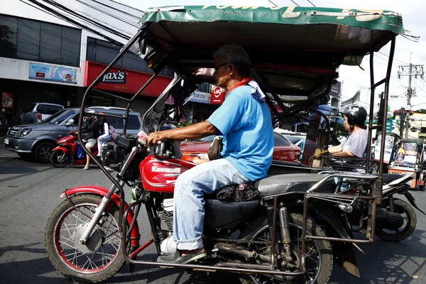 Motorista triciclo dirige seu veículo ao longo da estrada movimentada . — Fotografia de Stock