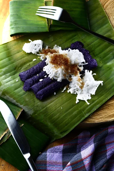 Foto di delicatezza filippina appena cotta chiamata puto bumbong o riso glutenoso viola macinato al vapore in tubi di bambù — Foto Stock