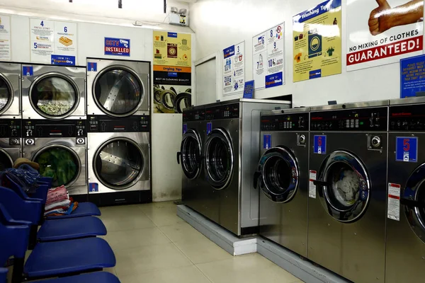 Pračka a spřádací sušičky uvnitř samoobslužné prádelny nebo prádelny. — Stock fotografie