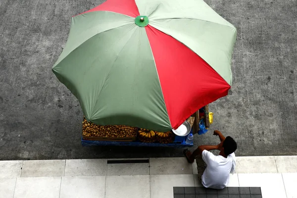 Fruit vendor selling banana and lanzones rests on sidewalk — Stock Photo, Image