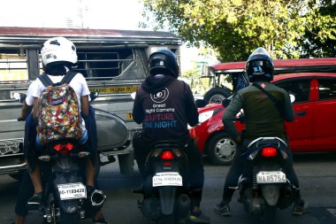 Motosiklet sürücüleri kavşakta trafik ışığının yeşil ışığını bekliyor..