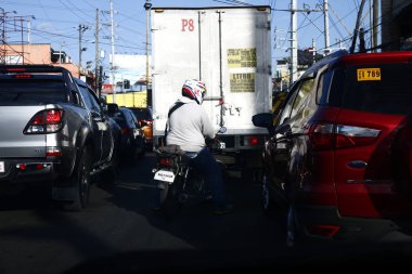 Motosiklet sürücüsü sıkışık bir yolda gidiyor..