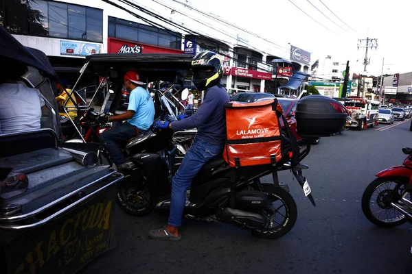 Homem de entrega de moto dirigir em torno de uma estrada congestionada de tráfego . — Fotografia de Stock
