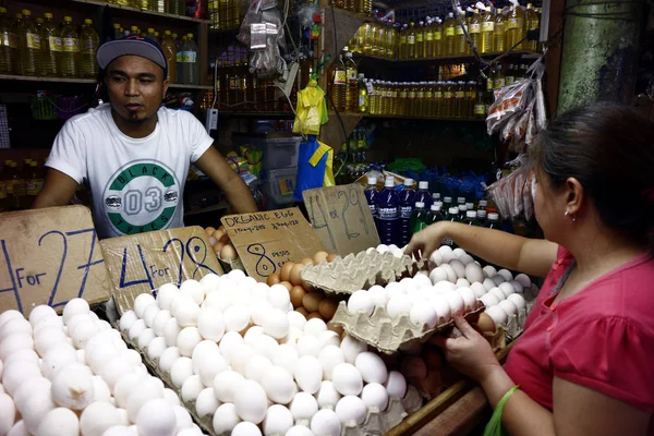 Clientes en un mercado público compran huevos de pollo frescos de un vendedor de huevos . — Foto de Stock