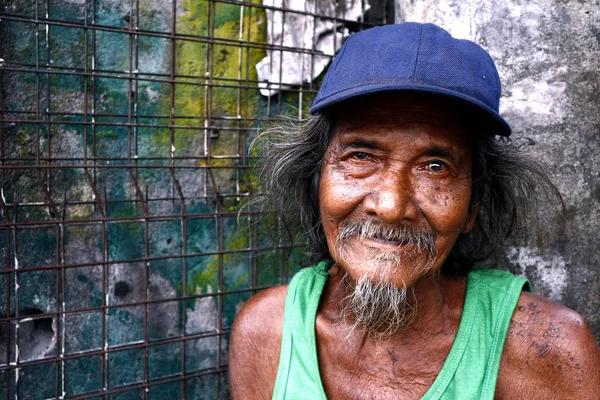 Взрослый филиппинский мужчина с седыми волосами и улыбкой на лице и позирует перед камерой . — стоковое фото
