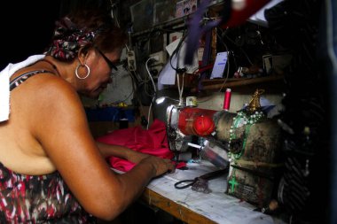 Antipolo Şehri, Filipinler - 1 Haziran 2020: Terzi, bir elbise terzisinde endüstriyel dikiş makinesi olan bir elbisenin bir parçasını diker.
