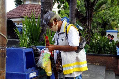Antipolo Şehri, Filipinler - 1 Haziran 2020: Çöpçü geri dönüşümlü atık madde aramak için çöp kutusuna gider.