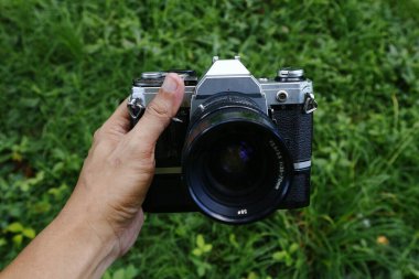 Açık hava parkındaki eski ve klasik tek mercek refleksi ya da SLR film kamerasının fotoğrafı.