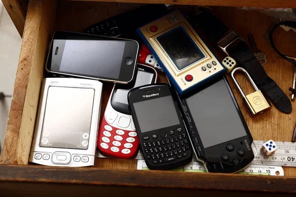 Antipolo Şehri, Filipinler - 29 Haziran 2020: Eski ve eski oyun konsollarının fotoğrafı, qwerty cep telefonu, akıllı telefon, uzun metrajlı telefon ve cep telefonu veya çekmecenin içindeki kişisel dijital asistan.