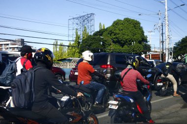 Cainta, Rizal, Philippines - July 7, 2020: Motorcycle riders along a busy and congested road during rush hour in the morning.