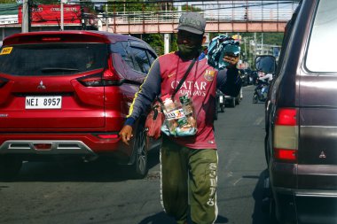 Antipolo City, Philippines - July 9, 2020: Street vendor sell cigarette, snack items and other items along a traffic congested road.