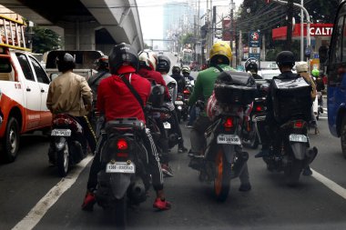 Quezon City, Filipinler - 28 Temmuz 2020: Motosiklet sürücüleri trafik lambasının yeşile dönmesini bekliyor.