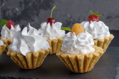 Protein krem ve gri arka plan üzerinde koyu taş plaka üzerinde meyveleri ile birkaç kek. Yakın çekim görünümü, seçici odak