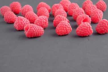 Koyu arka plan üzerinde olgunlaşmış doğal ahududu. Yakın çekim görünümü. Metin için yer kopyalayın