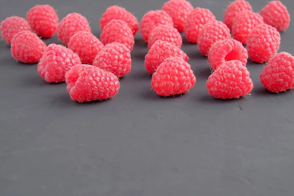 Koyu arka plan üzerinde olgunlaşmış doğal ahududu. Yakın çekim görünümü. Metin için yer kopyalayın