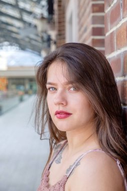 Bir tuğla duvar yakınındaki güzel bir genç kız portresi. Closeup görünümü