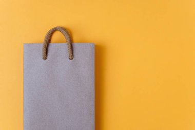 Zanaat alışveriş çantası sarı Kağıt arka plan üzerinde kağıt. Mağaza ve satış konsepti. 