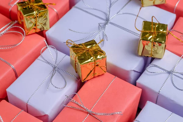 いくつか小さな黄金色プレゼントに上記プレゼントの赤と薄紫色の紙に包まれた 銀ひもと結ばれます お祝いの言葉の選択が表示されます セレクティブ フォーカス クローズ アップ ビュー — ストック写真