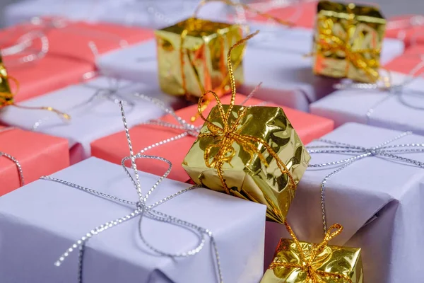 いくつか小さな黄金色プレゼントに上記プレゼントの赤と薄紫色の紙に包まれた 銀ひもと結ばれます 選択は メリー クリスマスをプレゼントします セレクティブ フォーカス クローズ アップ ビュー — ストック写真