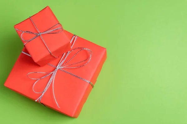 つのお祝いプレゼントは赤い紙に包まれ 緑のパステル調の背景に銀ひもを結んだ おめでとう概念 コピー領域のためのギフトの選択 セレクティブ フォーカス クローズ アップ ビュー — ストック写真