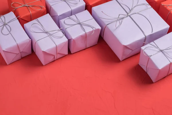 プレゼントのミックスは ライラック 赤い紙に包まれた 汚れた背景が赤に銀の糸と結ばれます 領域をコピーします 配送と包装のビジネス コンセプト — ストック写真