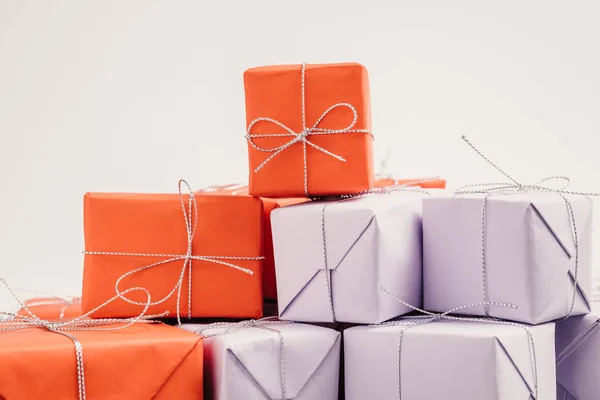 ギフトの多くは赤と薄紫色の紙に包まれた 白地に銀のひもと結ばれます 報酬と励まし概念へのプレゼントを準備しています クローズ アップ表示 選択と集中 — ストック写真