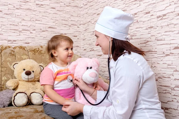 La doctora está escuchando a un niño con estetoscopio en casa. — Foto de Stock