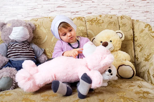 Lindo niño jugando médico o enfermera con juguetes de peluche en casa . — Foto de Stock