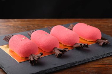 Karanlık taş şeker şeklinde dört kırmızı mini Mus kek