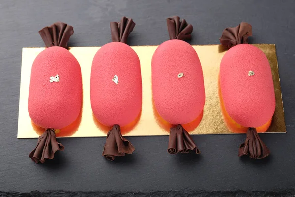 Négy piros mini mousse süteményeket, édességet a sötét kő plat alakja — Stock Fotó