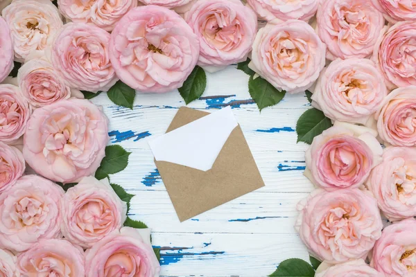 Composición de flores. Sobre abierto en el marco de rosas rosadas sobre fondo de madera envejecida . — Foto de Stock