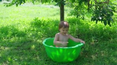 Açık bebek banyosu. gülümseyen bebek banyo yapıyor ve küçük küvete sıçratıyor. Hapiness ve sevinç kavramı