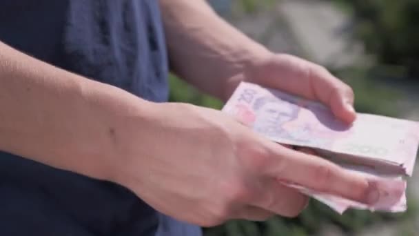 Мужчины руки подсчитывают связки банкнот номиналом 200 гривен . — стоковое видео