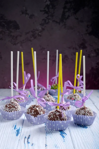 Bolo pops chocolate revestido com aspersão na mesa de mesa de madeira no fundo escuro com espaço de cópia — Fotografia de Stock