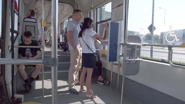 Cracovia Polonia - 08.24.2019: pareja de pasajeros lanzando monedas en los billetes de la máquina expendedora para el transporte público en tranvía — Vídeos de Stock