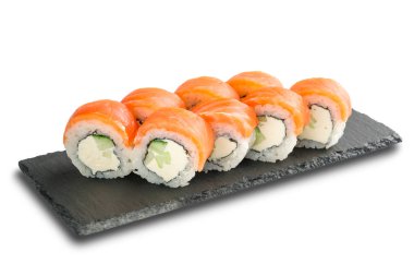 Siyah kayrak veya taş şist yüzeyinde somon, salatalık, nori yaprağı ve Krem Peynir ile Suşi Rolls izole