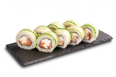 Siyah kayrak veya taş şist yüzeyinde somon, salatalık, nori yaprağı ve Krem Peynir ile Suşi Rolls izole