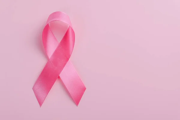Różowa wstążka na różowym tle. Koncepcja miesiąca świadomości raka piersi — Zdjęcie stockowe