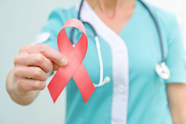 HIV hastalığı için kırmızı kurdele. Doktorun elinde farkındalık. 1 Aralık Dünya AIDS Günü konsepti..