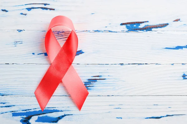 木製のテーブルの上に赤いリボン。12月1日世界エイズデー、 HIV感染者キャンペーン. — ストック写真