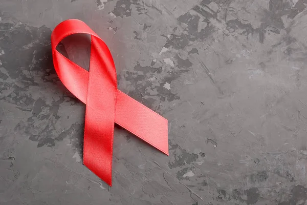 Red ribbon on a concrete background. 1 December World AIDS Day, HIV illness campaign. — ストック写真
