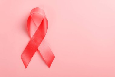 Pembe arka planda kırmızı kurdele. 1 Aralık Dünya Yardım Günü, HIV hastalığı kampanyası.