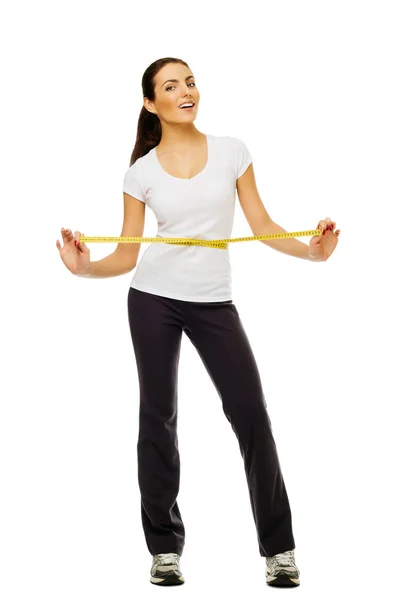 年轻妇女测量她的腰围用测量带在白色背景. — 图库照片