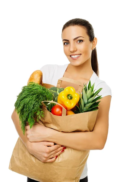 Jovem bela menina morena segurando um pacote com alimentos, frutas frescas e legumes. Isolado sobre fundo branco — Fotografia de Stock