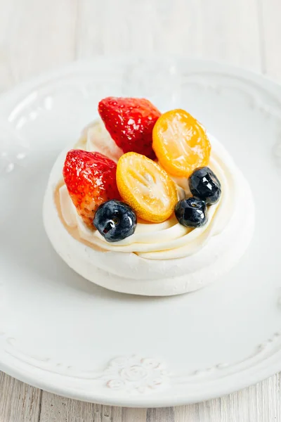 Pavlovas habcsók torta tejszínnel és mázas gyümölcstállal fehér táblán — Stock Fotó