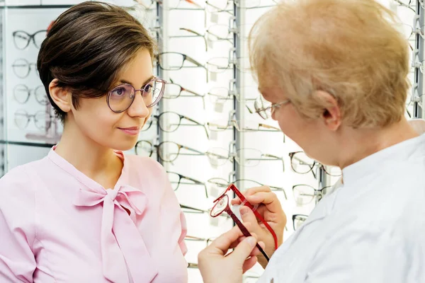 Vrouw consulteert met specialist in optiek winkel — Stockfoto