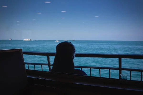 Menina em fones de ouvido em um barco no mar — Fotografia de Stock